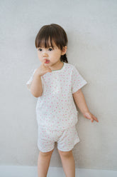 AVAUMA baby girl wearing sugar berry floral short sleeve pajama set